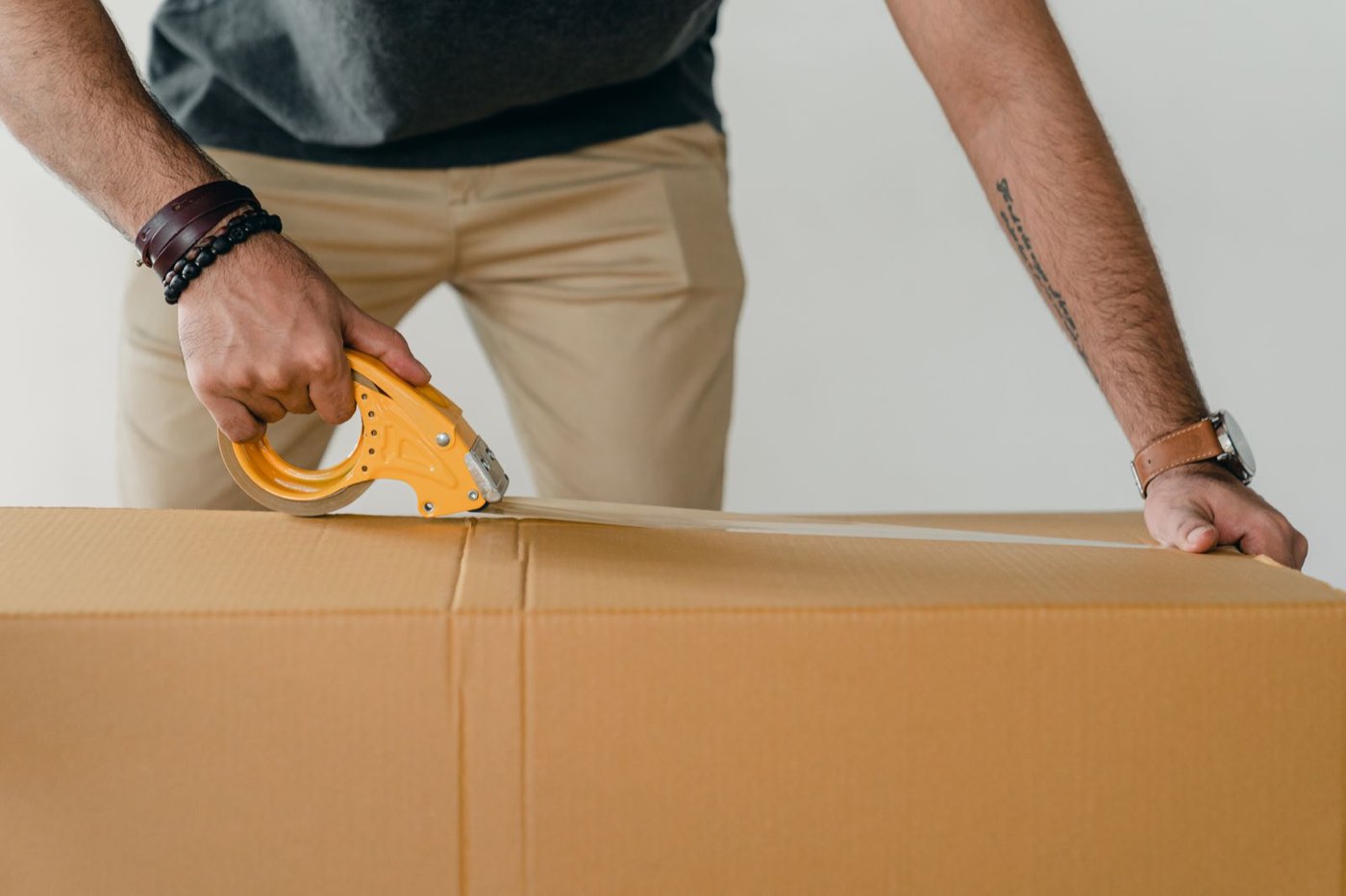 Sealing a packed cardboard box with a tape gun